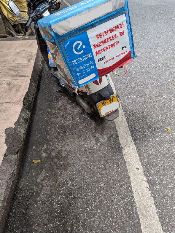 貌似是因为前几周外卖员罢工的事情，现在骑手后面的标语从交规提醒变成了「反有组织犯罪法」宣传，后备箱上面还有疑似标记骑手的代号（已打码处理）