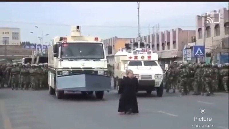 七五惨案发生后，维吾尔女性走向街头要回他们的兄弟，她们的丈夫，她们的儿子，永远不要忘记这位勇敢的拄着拐杖挡住军警车辆的维吾尔母亲！By