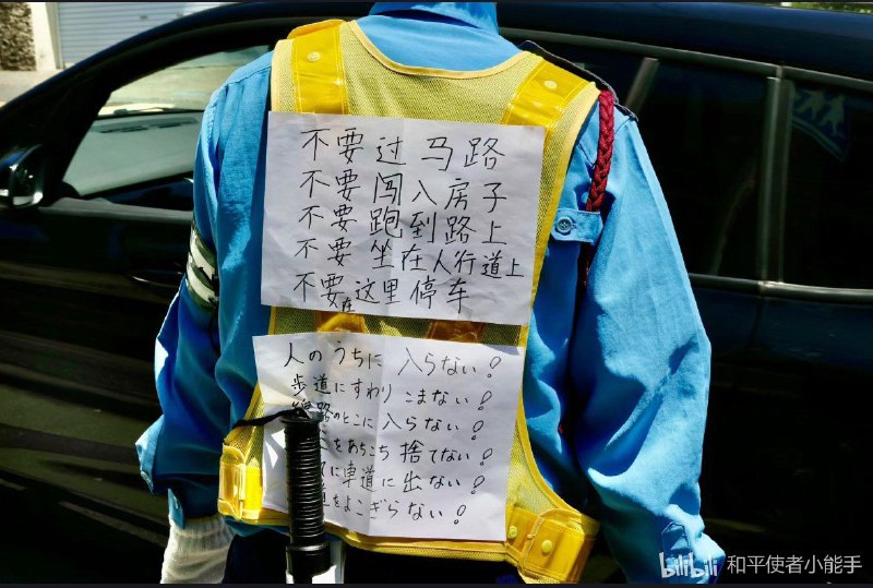 在中国游客聚集的著名景点「镰仓高校前」，一位日本警员背后着中日双语警告那些不遵守交通规则的中国游客！By